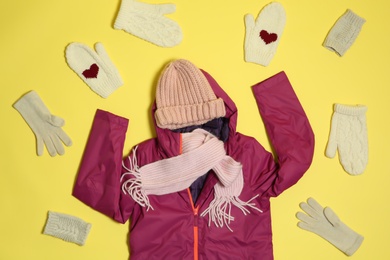 Photo of Flat lay composition with warm clothes for winter vacation on color background