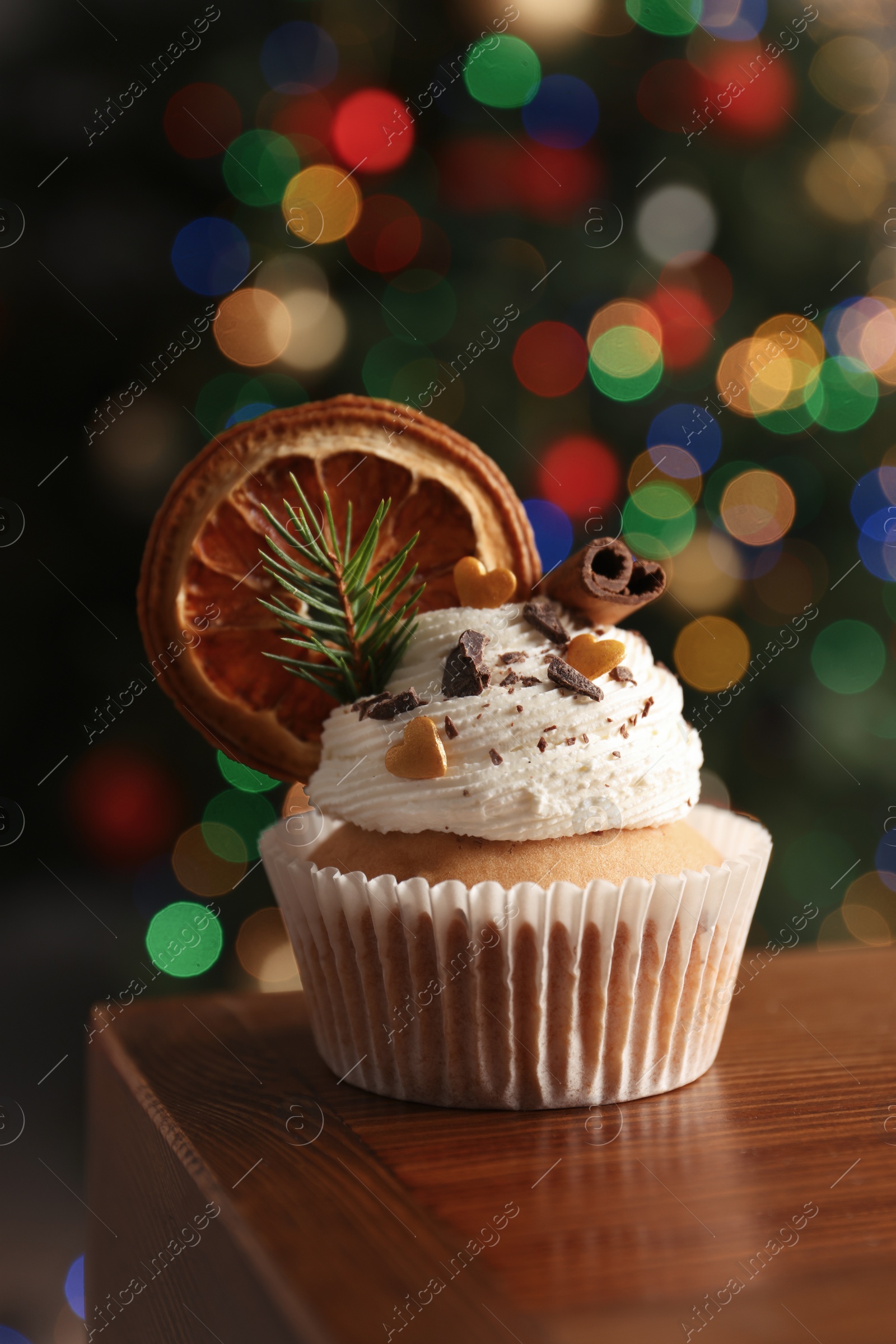 Photo of Beautifully decorated Christmas cupcake on wooden table indoors