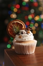 Photo of Beautifully decorated Christmas cupcake on wooden table indoors