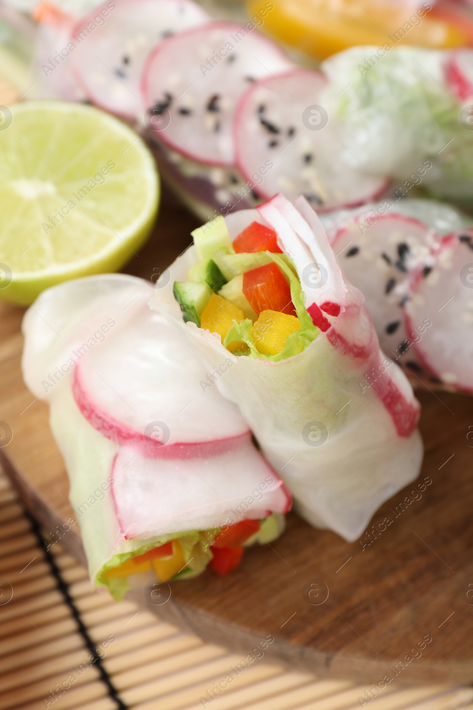 Photo of Delicious spring rolls and lime on table, closeup