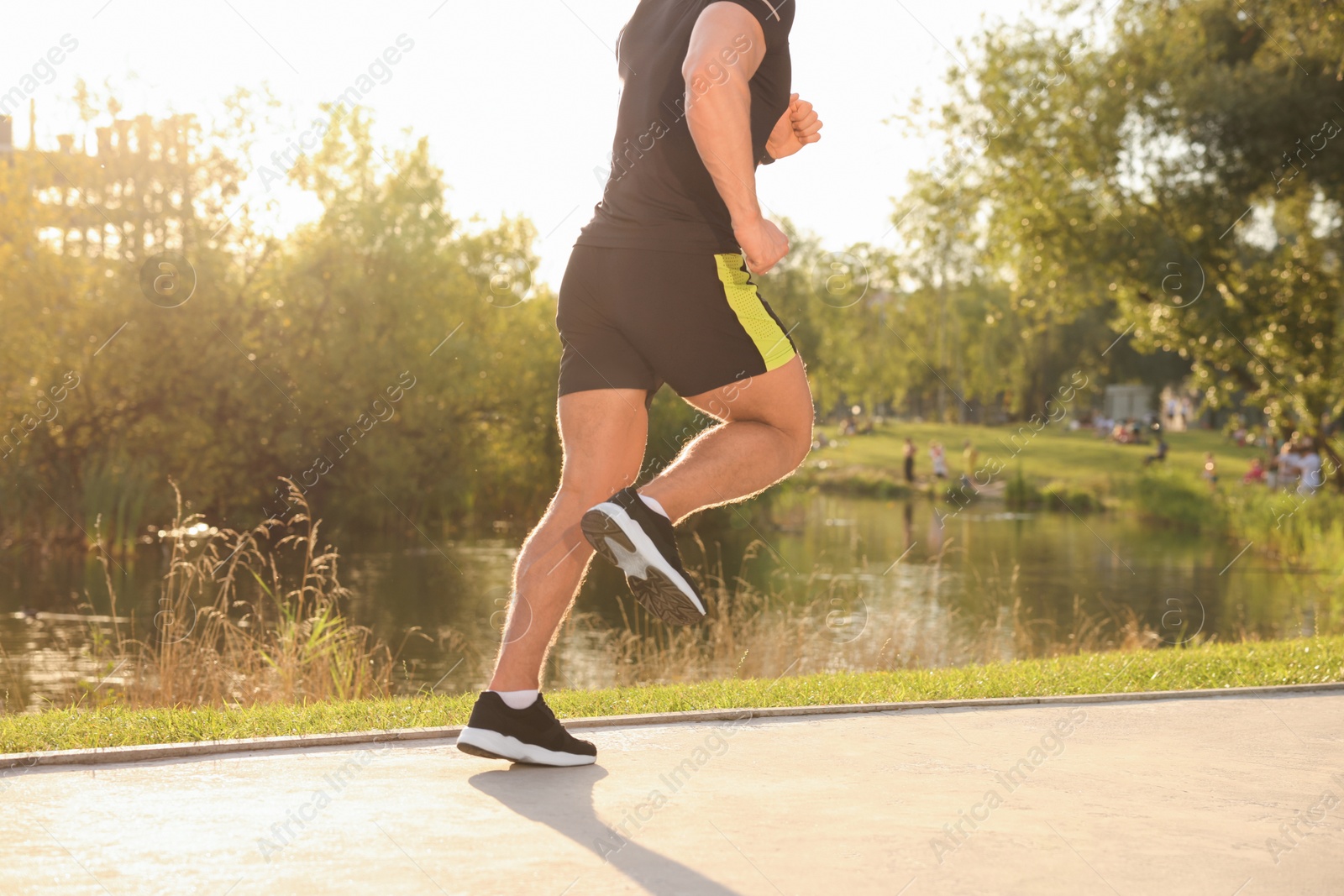 Photo of Man running near pond in park, closeup