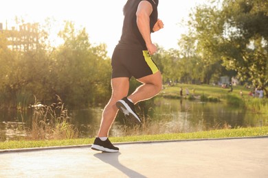 Man running near pond in park, closeup