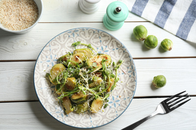 Photo of Delicious salad with roasted Brussels sprouts on white wooden table, flat lay