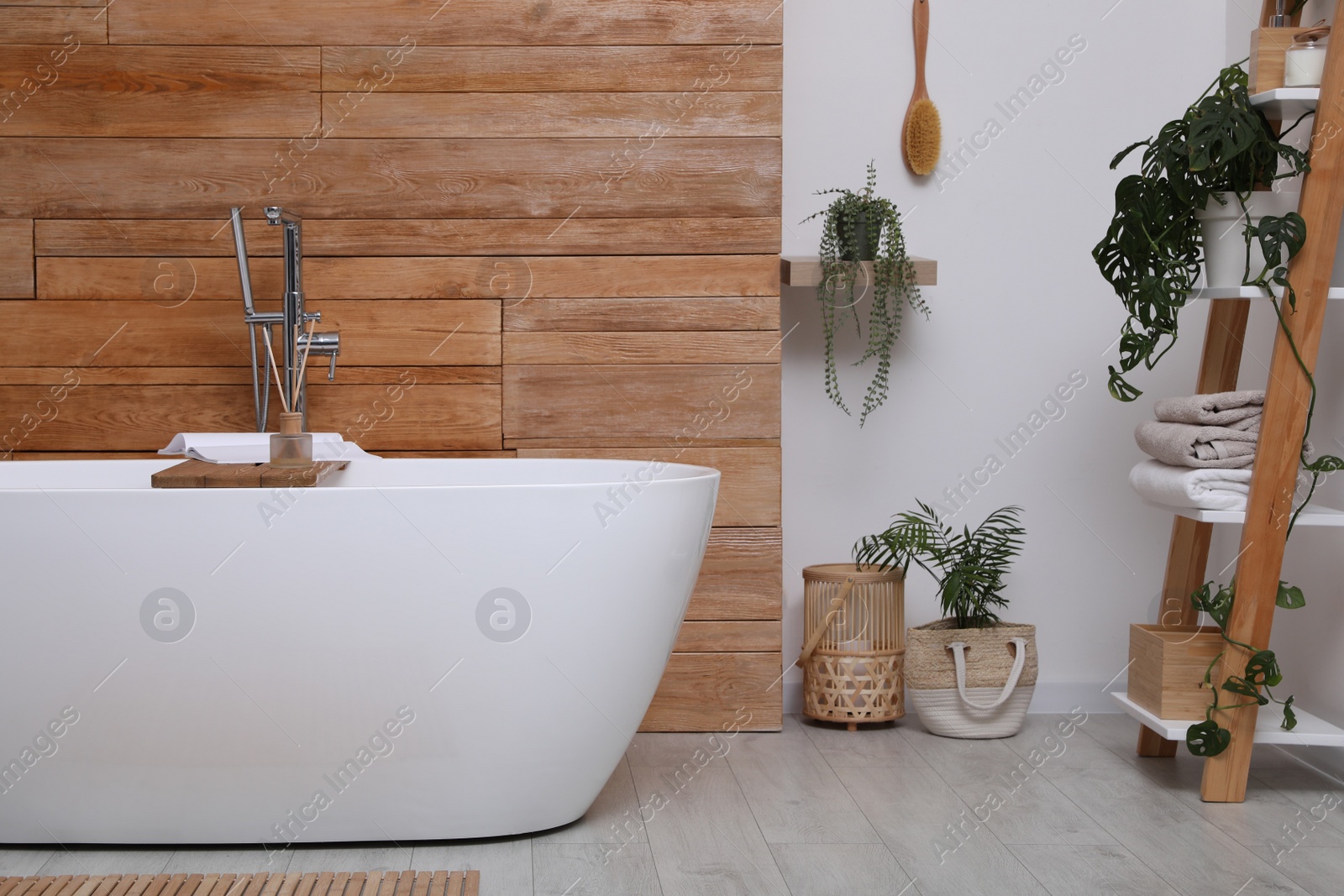 Photo of White tub and beautiful plants in bathroom, Interior design