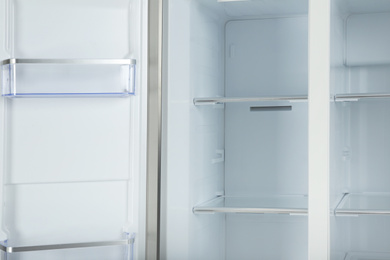 Shelves of empty modern refrigerator, closeup view