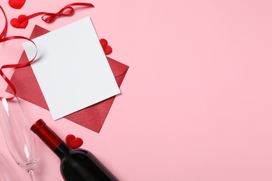 Photo of Flat lay composition with blank card on pink background, space for text. Valentine's Day celebration