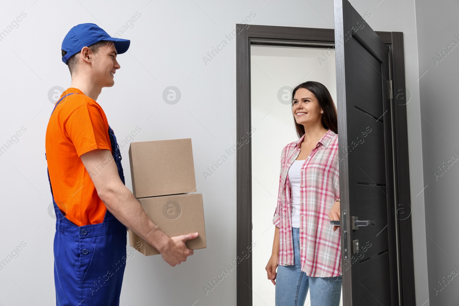 Photo of Woman receiving parcels from courier at home