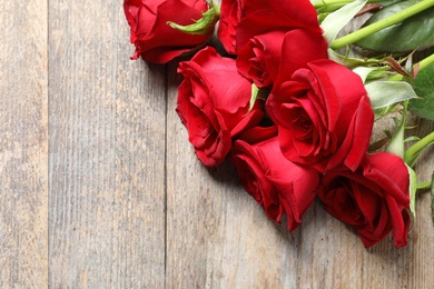 Beautiful red rose flowers on wooden background