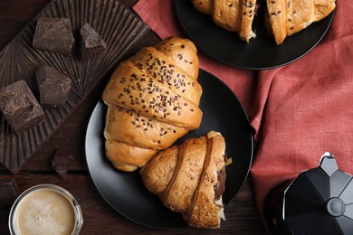 Flat lay composition with tasty croissants, chocolate and coffee on wooden table