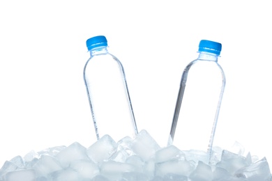 Bottles of water on ice cubes against white background