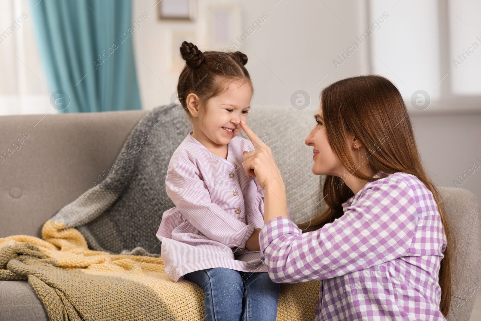 Photo of Young mother with little daughter at home