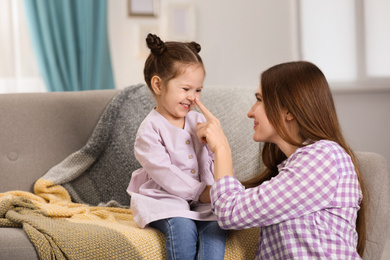 Photo of Young mother with little daughter at home