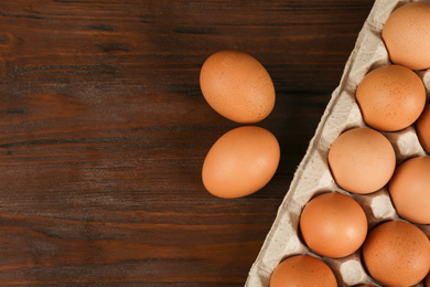 Raw chicken eggs on wooden table, flat lay. Space for text