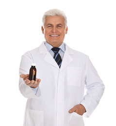 Senior pharmacist with syrup on white background