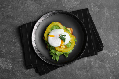 Photo of Delicious poached egg sandwich served on grey table, flat lay