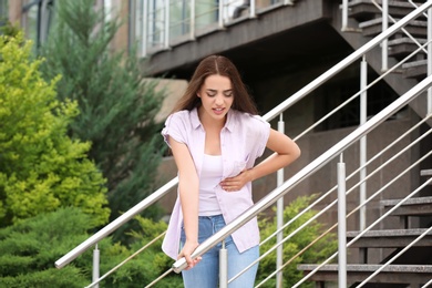 Photo of Young woman having chest pain outdoors. Heart attack