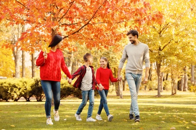 Happy family with children walking in autumn park
