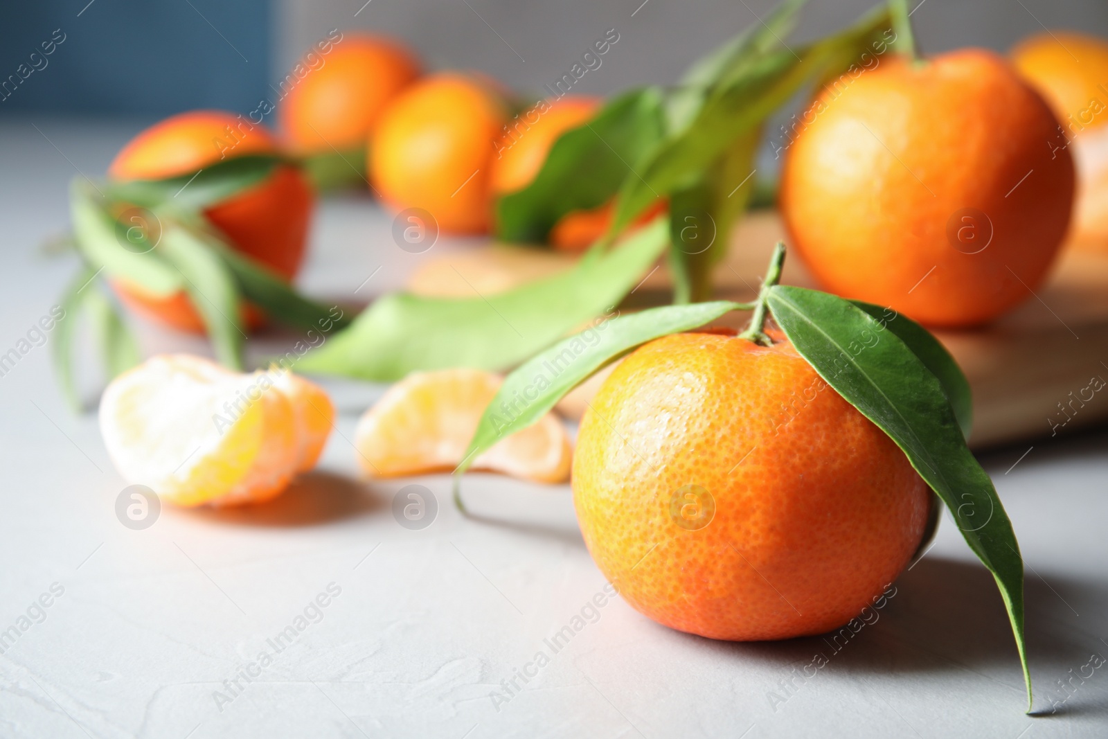 Photo of Ripe tangerine with leaves on table. Space for text