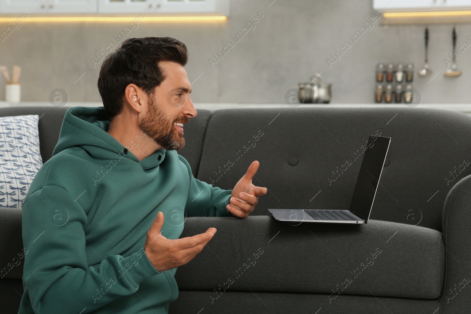 Photo of Man having video chat via laptop at home