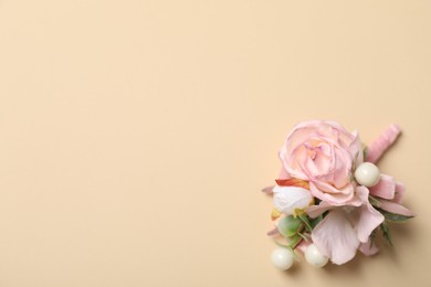 Photo of Stylish pink boutonniere on beige background, top view. Space for text