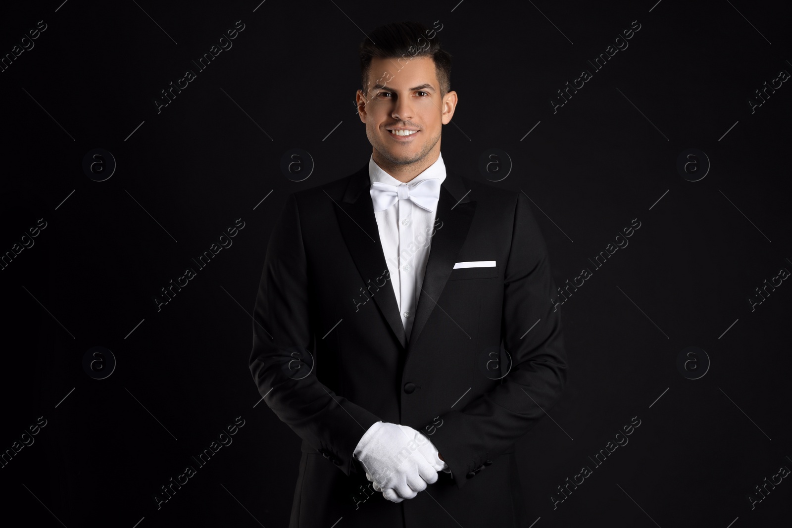 Photo of Handsome butler in elegant uniform on black background