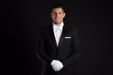 Photo of Handsome butler in elegant uniform on black background