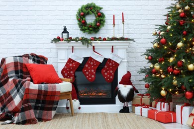 Cosy room with tree and fireplace decorated for Christmas. Interior design