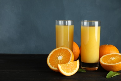 Composition with orange juice and fresh fruit on table, space for text