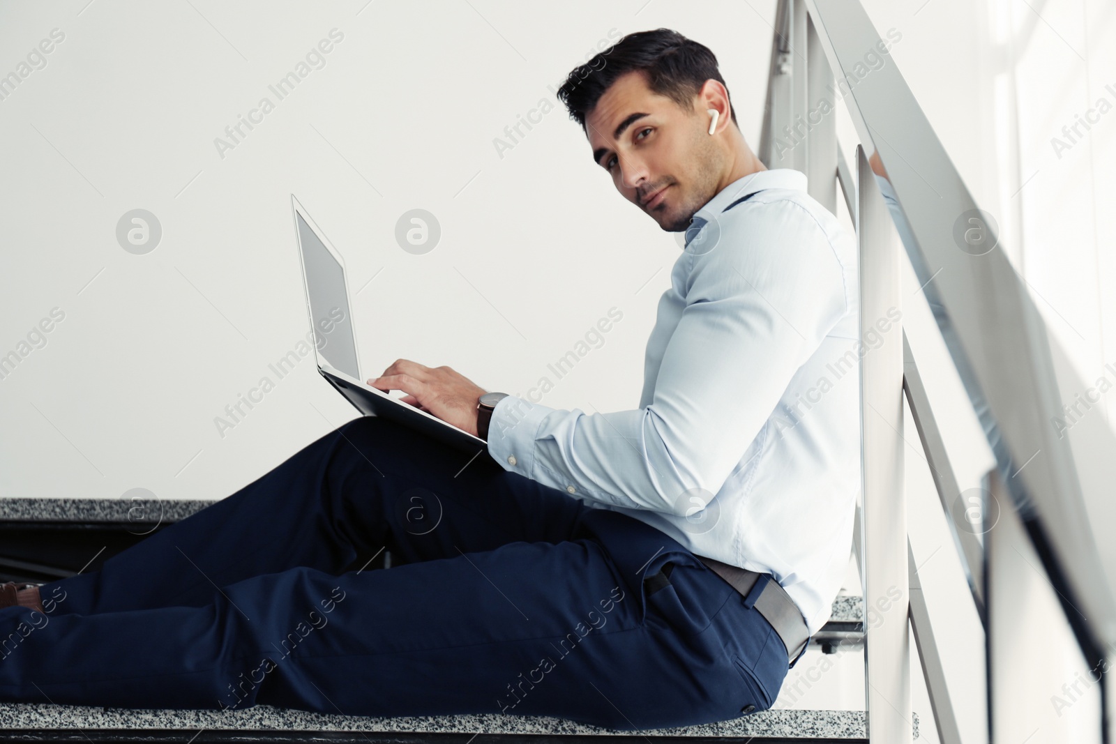 Photo of Portrait of young man with laptop indoors