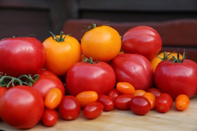 Different sorts of tomatoes on wooden table