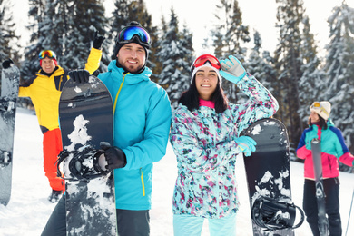 Photo of Happy couple with friends on snowy slope. Winter vacation