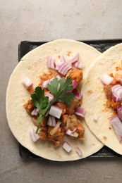 Photo of Delicious tacos with vegetables and meat on grey textured table, top view