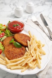 Photo of Delicious fried breaded cutlets with garnish served on white marble table