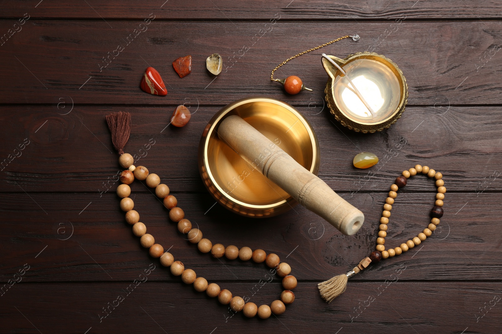 Photo of Flat lay composition with golden singing bowl on wooden table. Sound healing