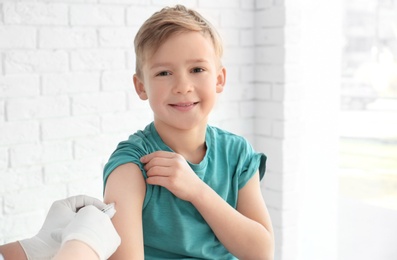 Doctor vaccinating little boy in hospital