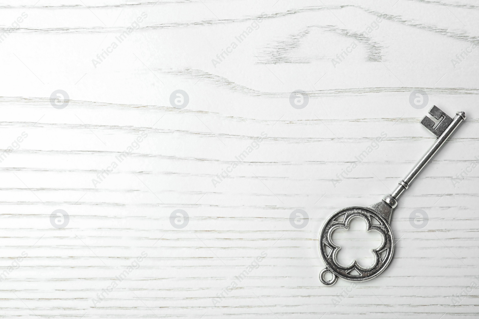 Photo of Old vintage key on wooden background, top view with space for text