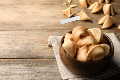 Tasty fortune cookies with prediction on wooden table, space for text