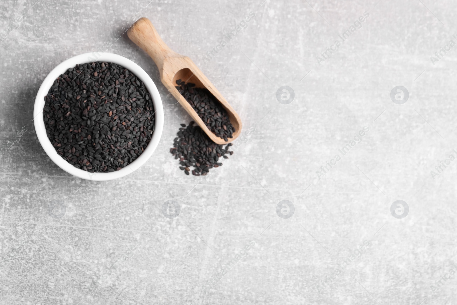 Photo of Black sesame seeds on grey table, flat lay. Space for text