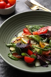 Photo of Delicious vegetable salad on black table, closeup