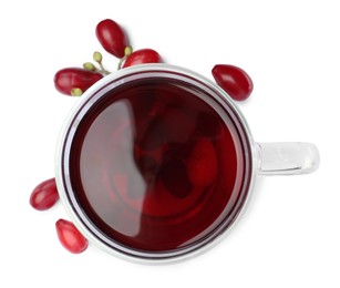 Photo of Glass cup of fresh dogwood tea and berries on white background, top view