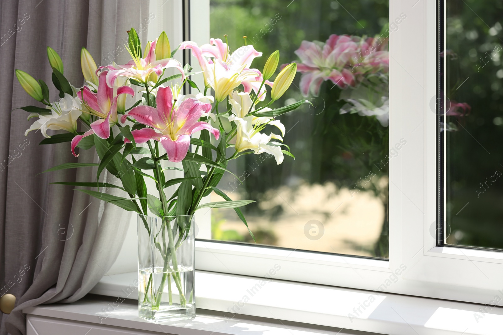 Photo of Vase with bouquet of beautiful lilies near window indoors. Space for text