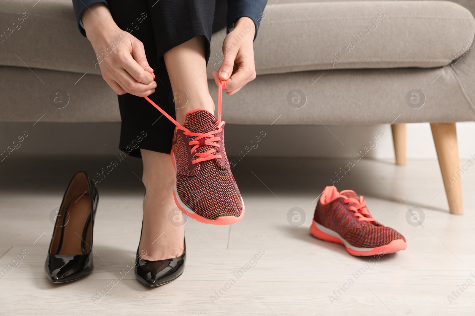 Photo of Woman changing shoes on sofa in office, closeup