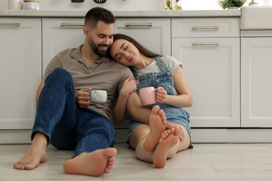Photo of Affectionate young couple spending time together in kitchen. Space for text