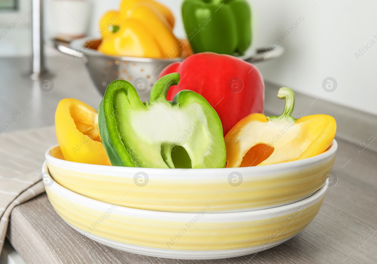 Photo of Plates with ripe paprika peppers on table