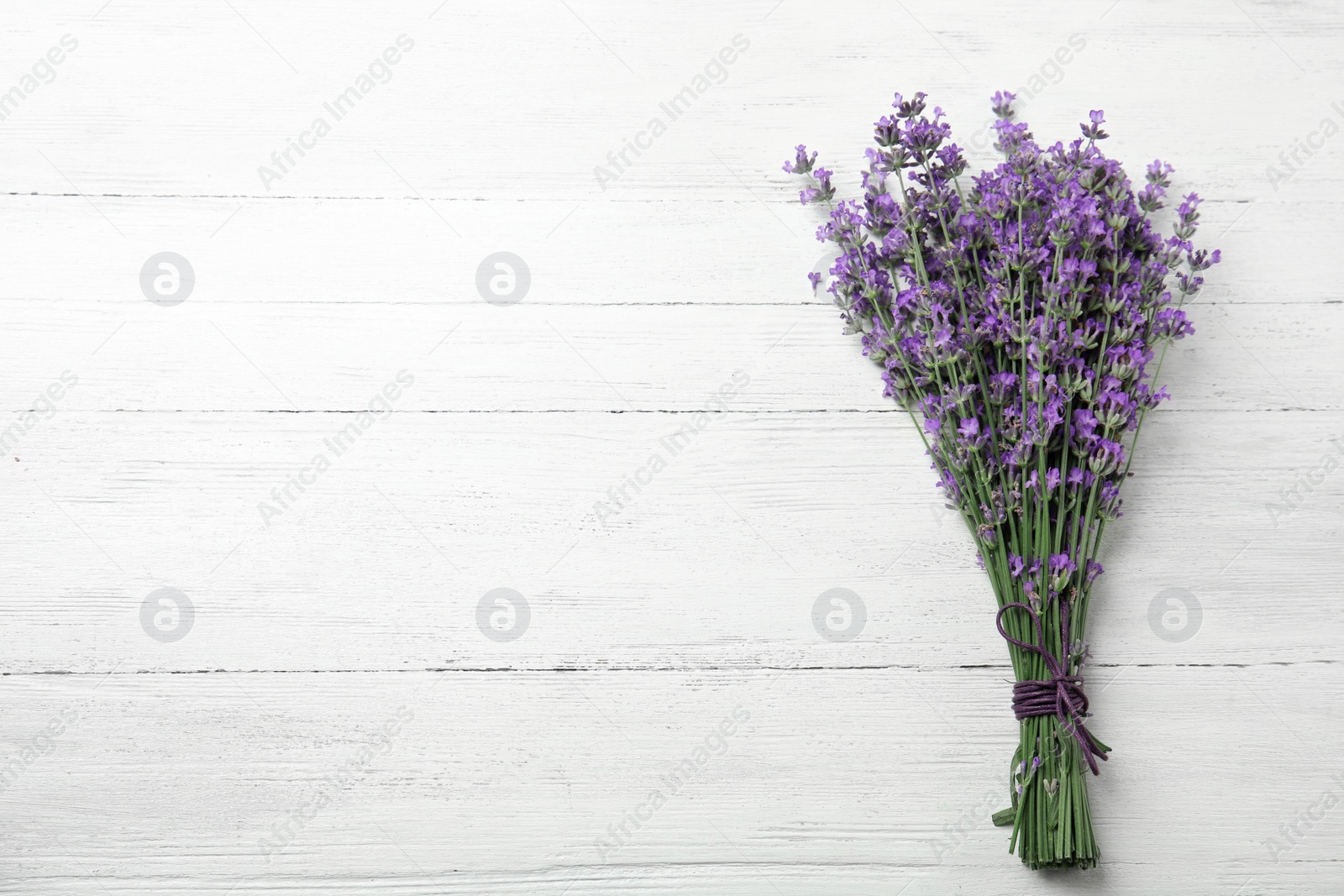 Photo of Beautiful tender lavender flowers on white wooden table, top view. Space for text