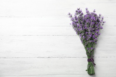 Photo of Beautiful tender lavender flowers on white wooden table, top view. Space for text