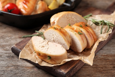 Wooden board with fried chicken breast on table, closeup