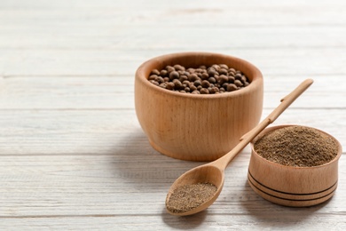 Composition with powdered pepper and corns in wooden dishware on table