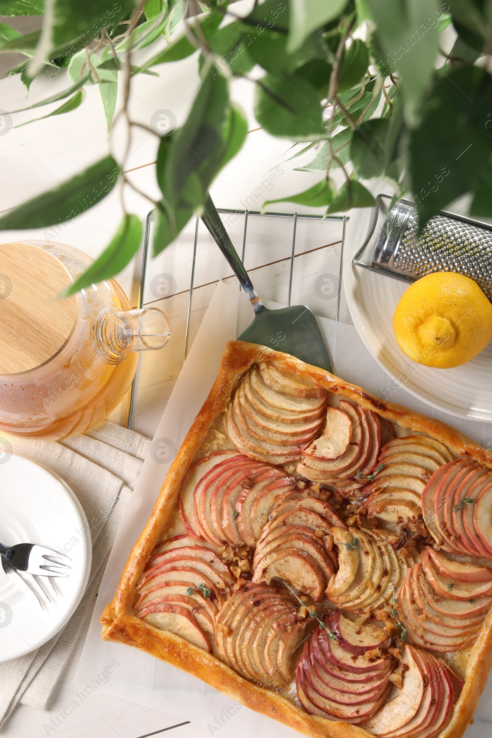 Photo of Freshly baked apple pie served on white wooden table, flat lay