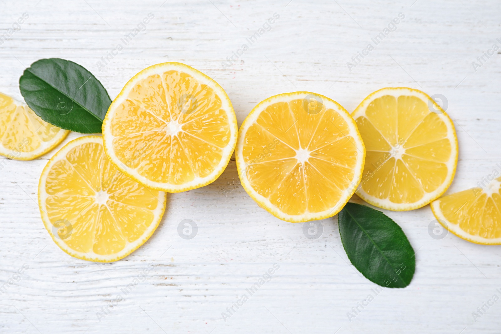 Photo of Flat lay composition with fresh ripe lemons on white wooden table